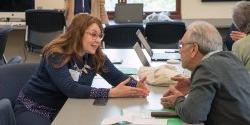 two faculty members talking across a table